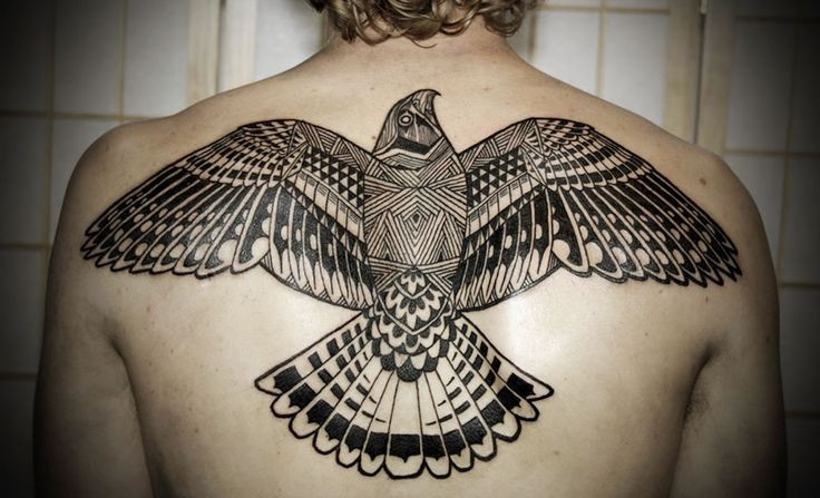 Black ink bird tattoo on upper back