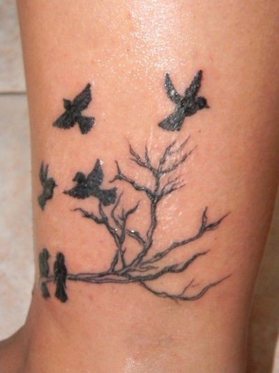 Tatuaje en la pierna, árbol fino con bandada de cuervos