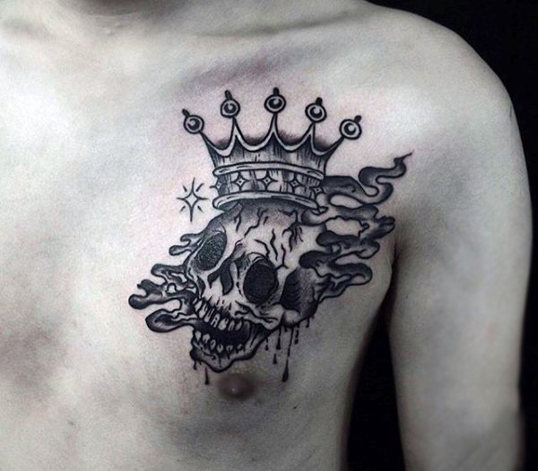 Black ink chest tattoo of human skull with crown