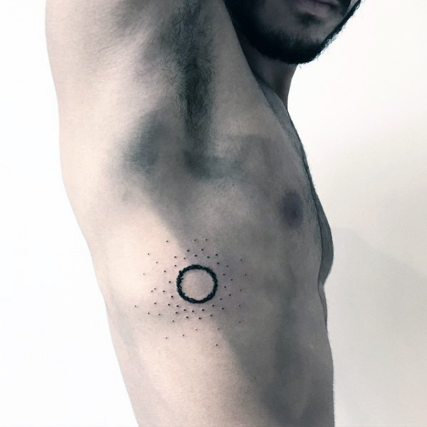 Black ink circle tattoo with black dots