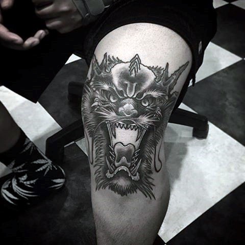 Black ink cool looking knee tattoo of demon head