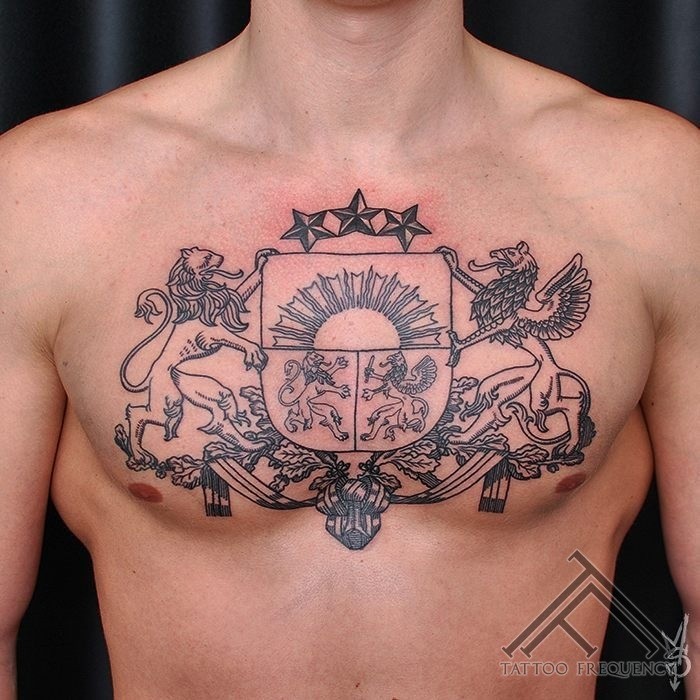 Black ink detailed chest tattoo of large ancient emblem