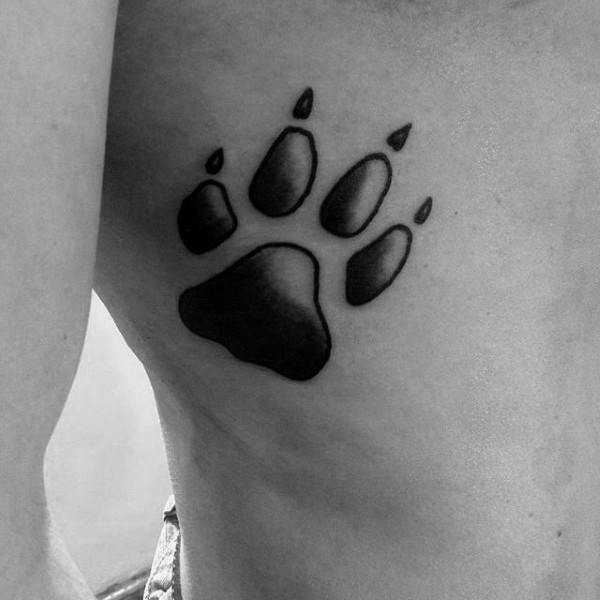Black ink detailed side tattoo of animal paw print