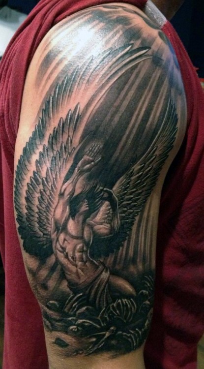 Black ink dramatic designed fallen angel tattoo on shoulder