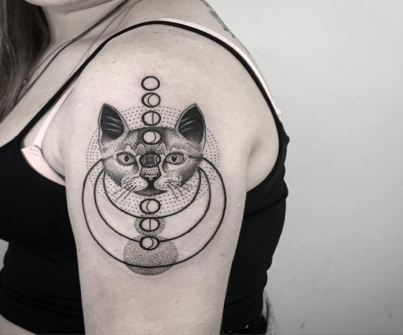 Black ink engraving style shoulder tattoo of cat head with planet parade