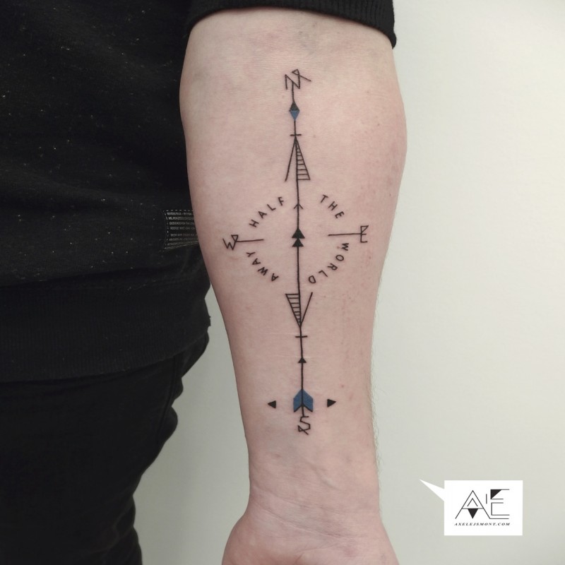 Black ink forearm tattoo of compass with lettering