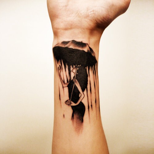 Black ink girl under an umbrella in rain wrist tattoo
