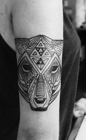 Tatuaggio nero sul braccio la testa del animale feroce