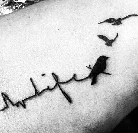 Black ink heart rhythm stylized with lettering life and black birds tattoo