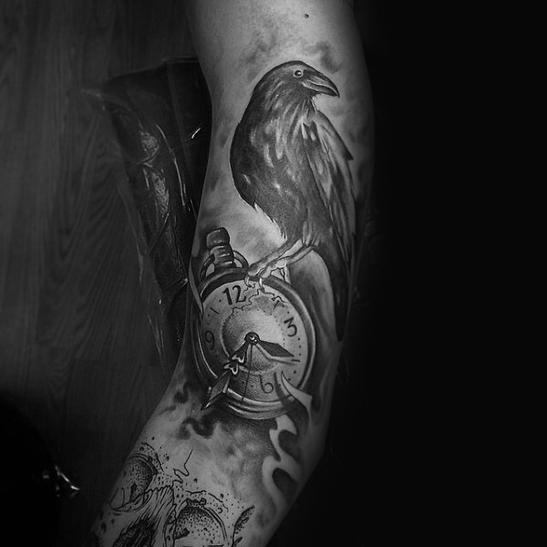 Black ink large arm tattoo of crow with clock