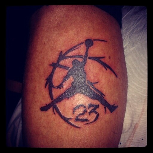 Black ink leg tattoo of basketball player