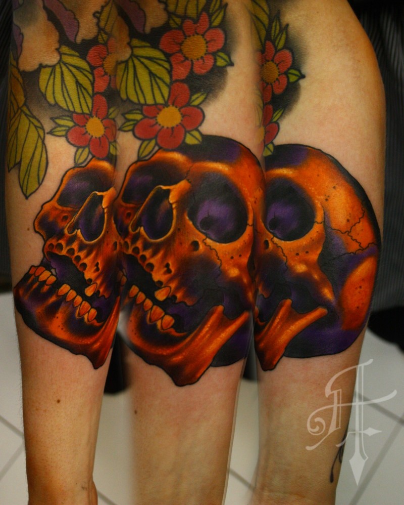 Black ink leg tattoo of human skull with cute flowers