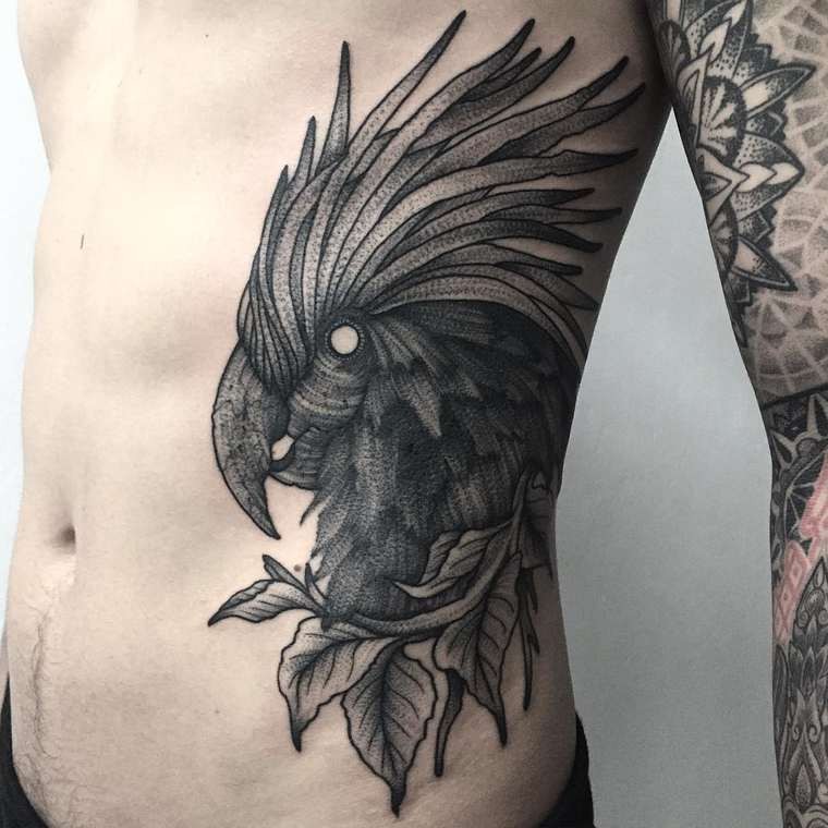 Tatuaje en el costado, 
 pájaro fascinante extraordinario con hojas, colores negro blanco