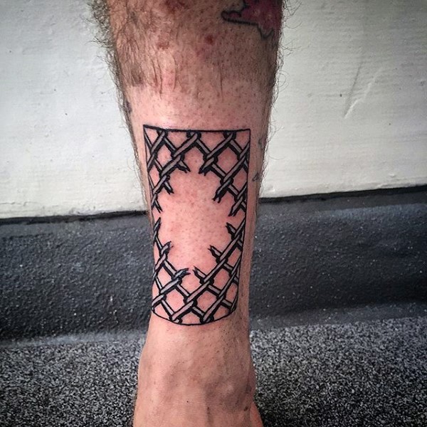 Black ink realistic looking corrupted fence tattoo on leg
