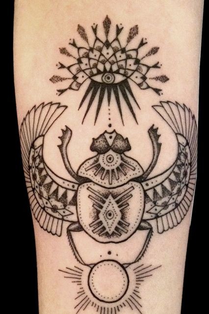 Tatuaje en la pierna, escarabajo con símbolod de sol y ojo