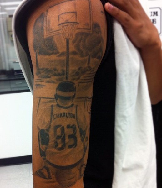 Black ink shoulder tattoo of basketball player