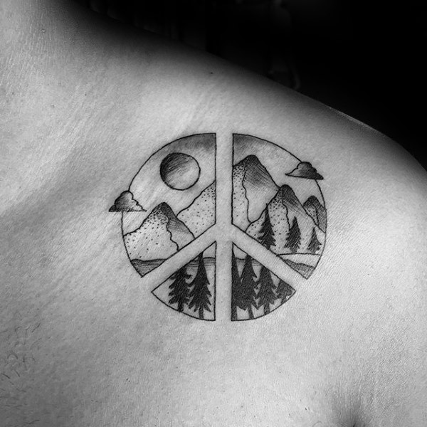 Black ink shoulder tattoo of pacific symbol stylized with mountains and forest