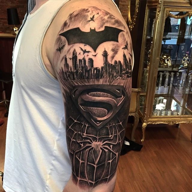 Black ink shoulder tattoo of various Super heroes emblems