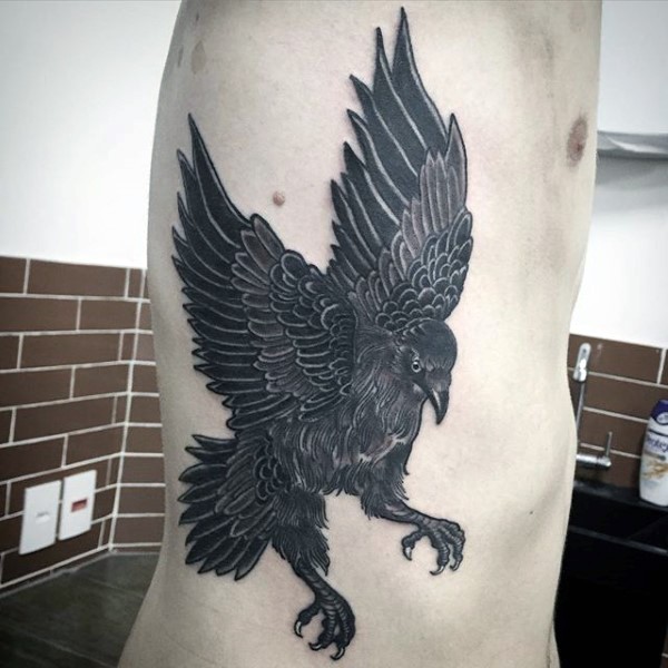 Black ink side tattoo of big dark crow