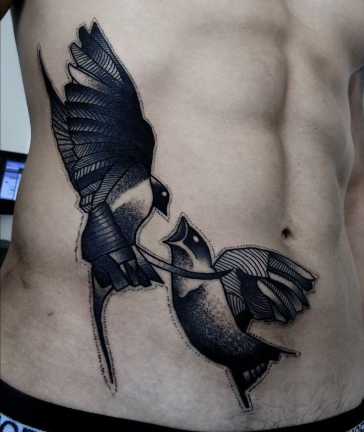 Black ink side tattoo of fighting birds