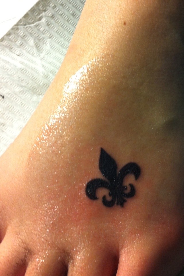 piccolo fleur de lis inchiostro nero tatuaggio sul piede