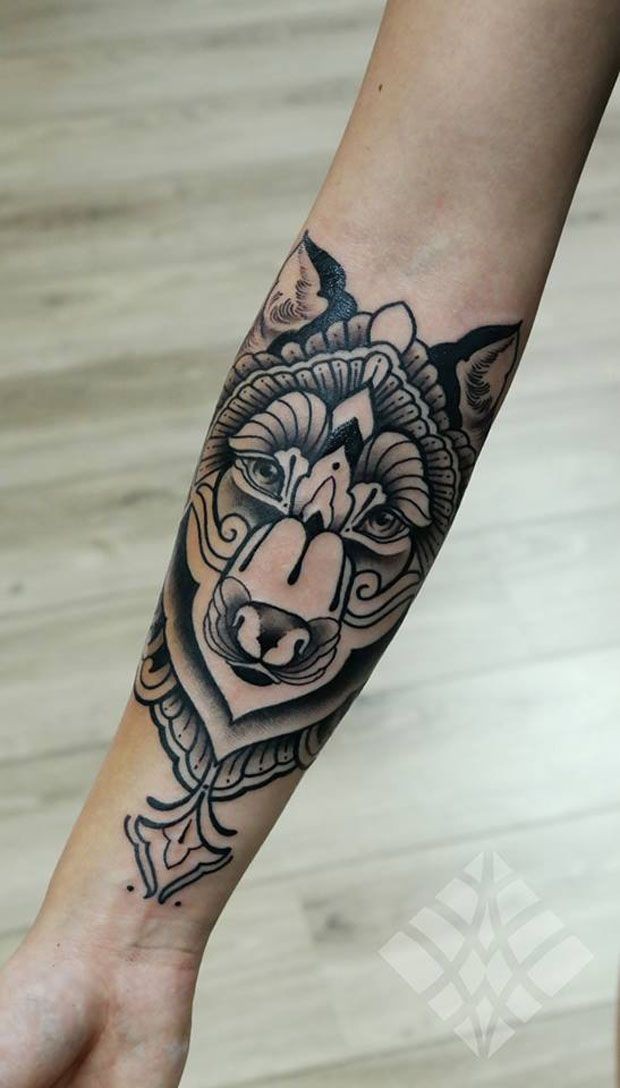 Black ink stylized wolf head forearm tattoo
