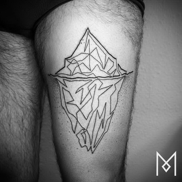 Black ink thigh tattoo of large iceberg