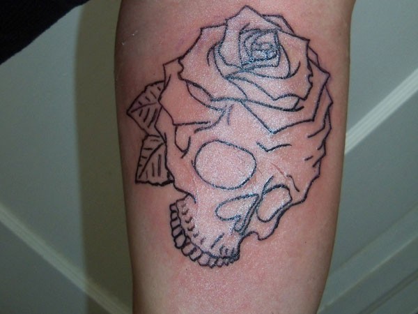 Black ink traditional skull with rose flower contour tattoo in homemade style