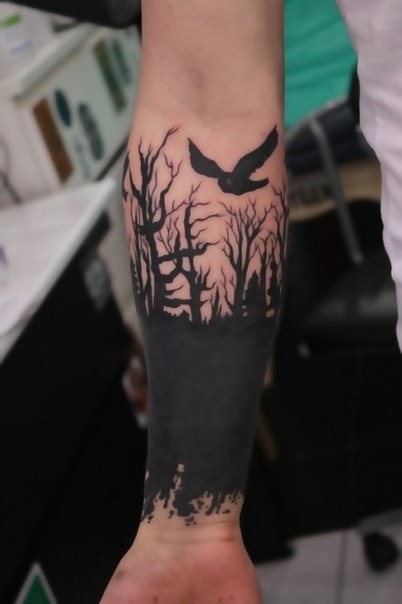 Tatuaje en la muñeca, bosque oscuro y ave, tinta negra