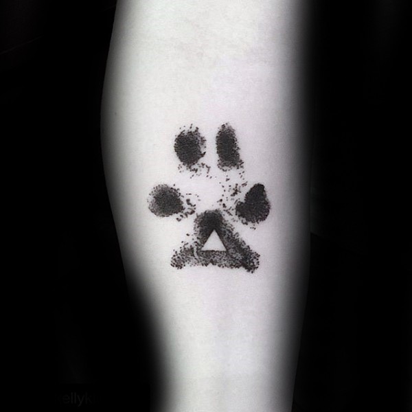 Black ink typical leg tattoo of animal paw print with triangle