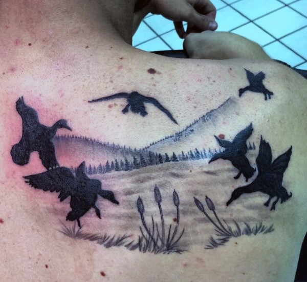 Black ink unusual looking flying ducks tattoo on shoulder