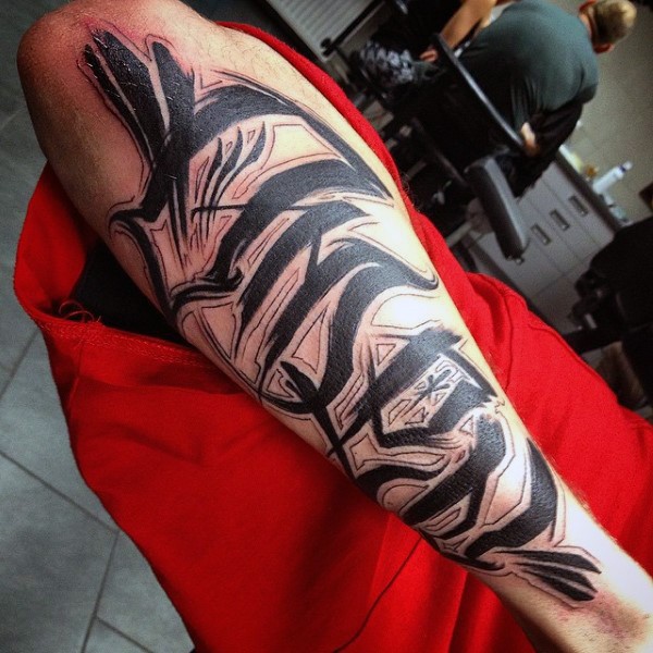 Black ink very detailed ambigram tattoo on arm