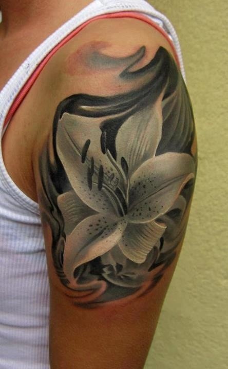 Black lily tattoo on shoulder