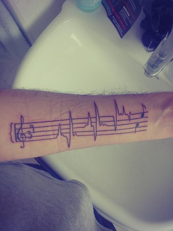 Tatuaje en el antebrazo, pauta musical con cardiograma