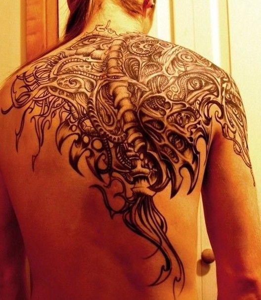 Black mechanical spine tattoo on back