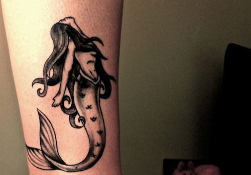 Tatuaje en la pierna,
sirena atractiva delgada