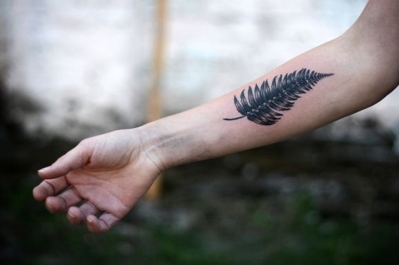Black one leaf fern forearm tattoo by Alice Carrier