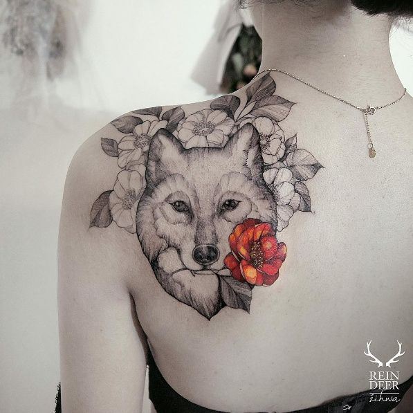 Tatuagem escapular estilo contorno preto de lobo segurando flor colorida por Zihwa