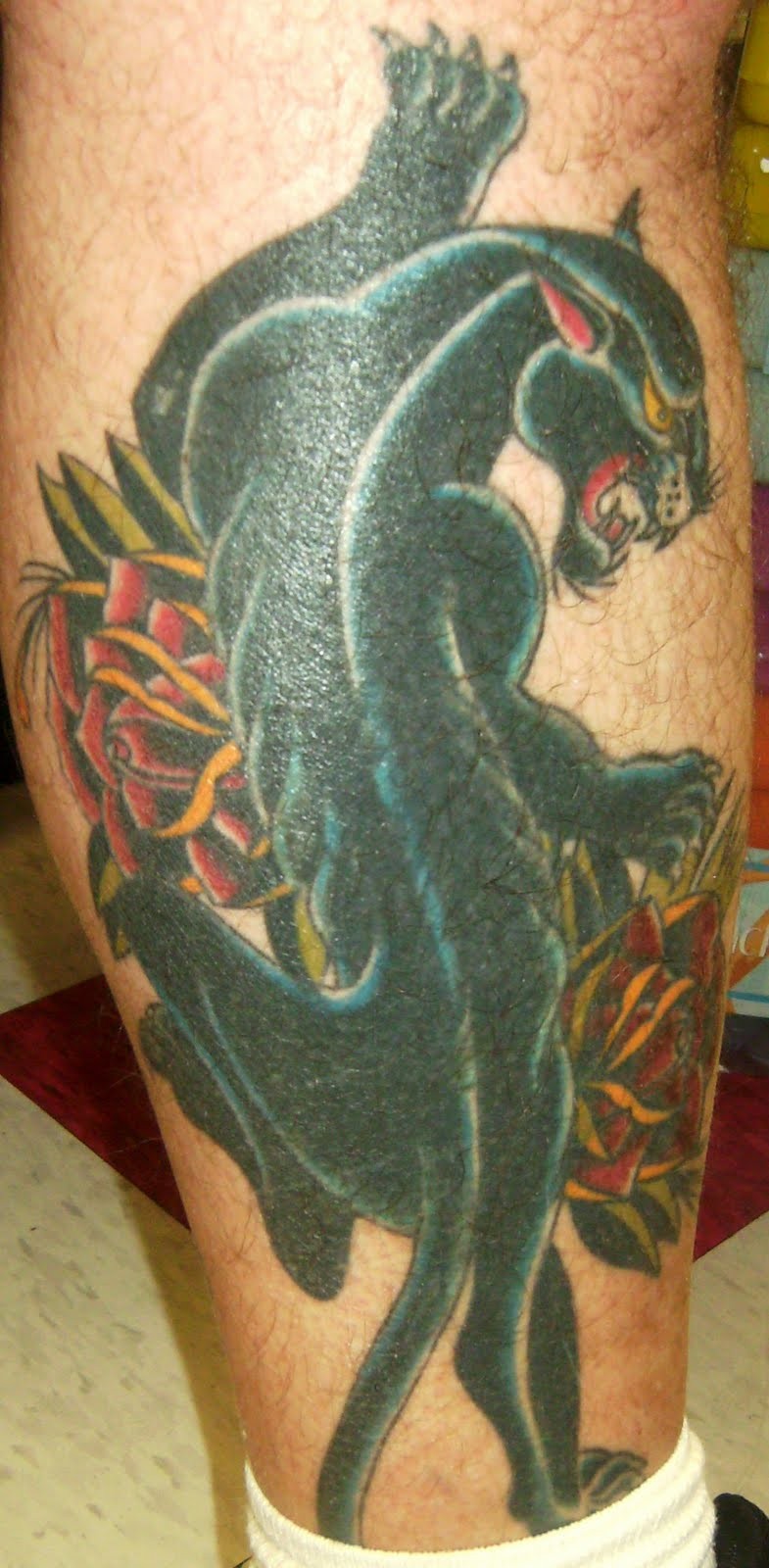 Black panther and roses tattoo on leg