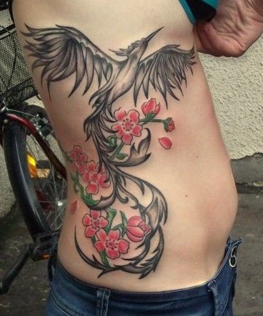 Black phoenix and flowers tattoo on ribs