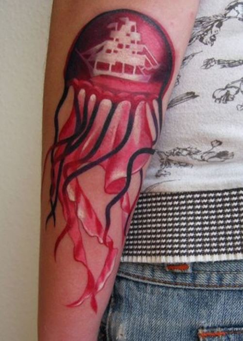 Tatuaje en el brazo, medusa rosa con un barco pintado en ella