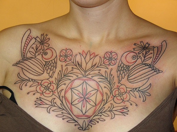 Tatuaje en el pecho, 
líneas rojos y negros de aves y flores