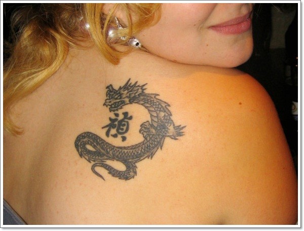 Black small chinese dragon tattoo on shoulder blade