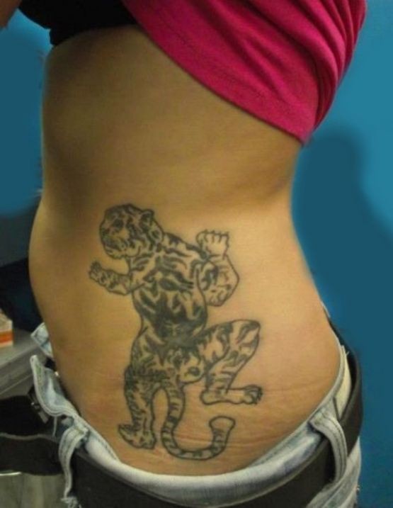 Black tiger climbing up tattoo on ribs
