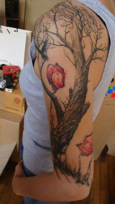 albero nero con fiori rossi tatuaggio su braccio