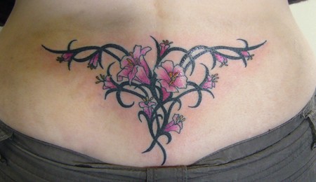 Black tribal and pink flowers tattoo on lower back
