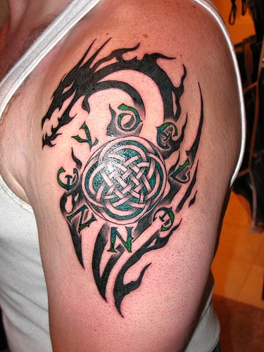 Black tribal dragon knot tattoo on shoulder