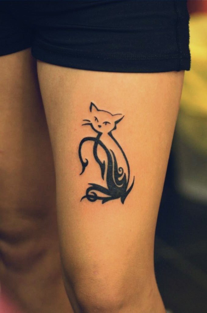 Black tribal style cat tattoo on thigh
