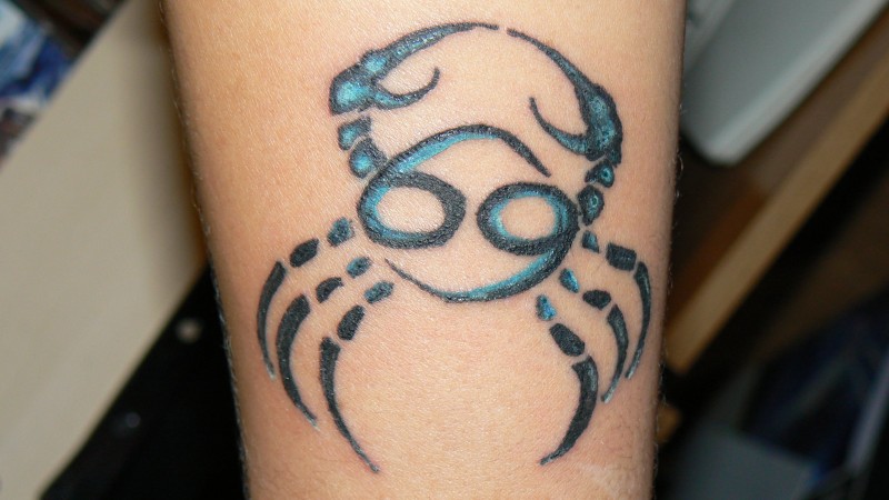 Black with blue crab tattoo on arm