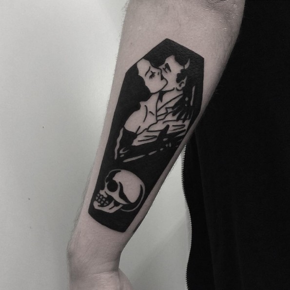 Blackwork style coffin shaped arm tattoo of creepy couple with skull